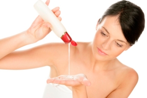 Woman pouring body lotion on hand