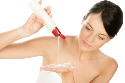 Woman pouring body lotion on hand